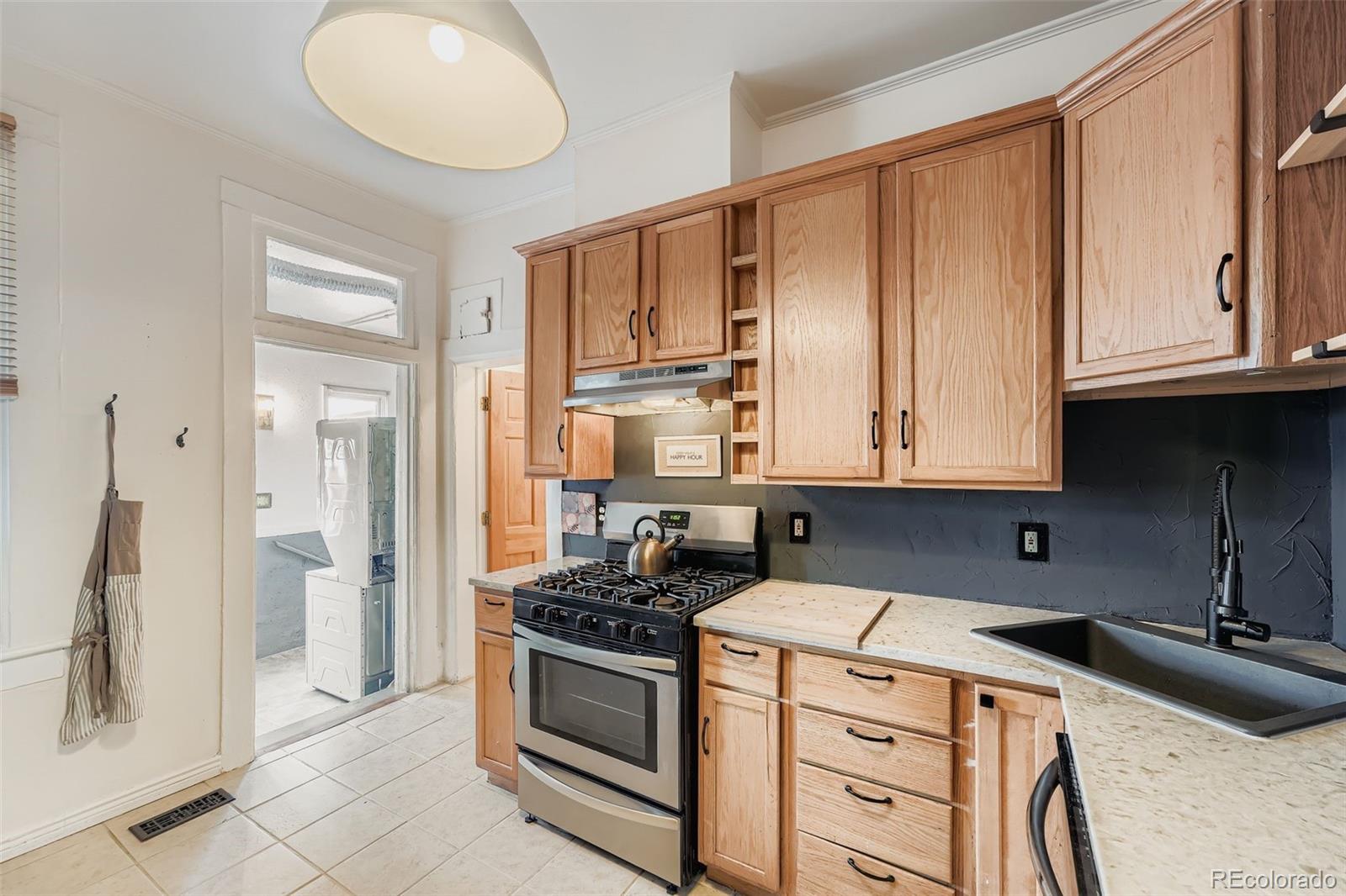 2955 Columbine Street Denver, CO 80205 - Photo 11 of 29 a kitchen with stainless steel appliances granite countertop a stove a sink and a refrigerator