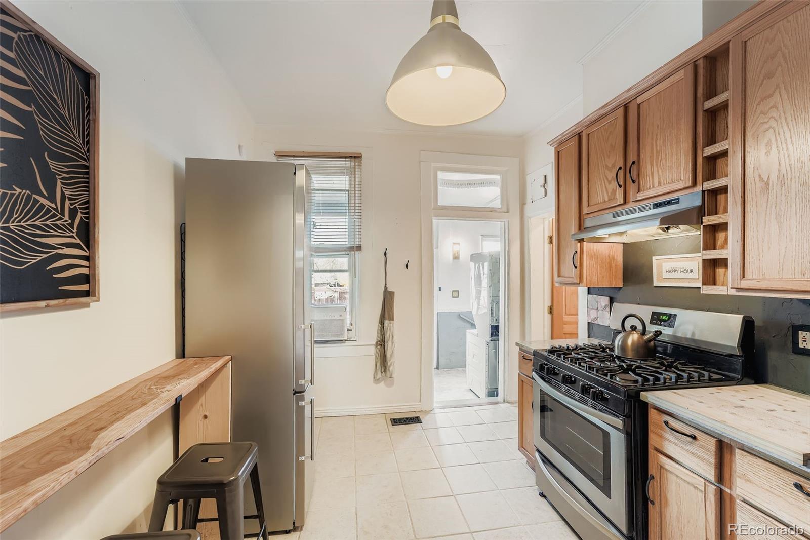2955 Columbine Street Denver, CO 80205 - Photo 12 of 29 a kitchen with stainless steel appliances granite countertop a stove and a refrigerator