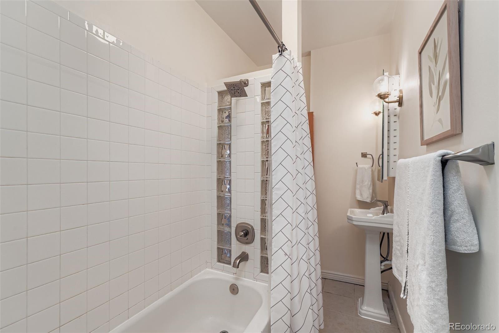 2955 Columbine Street Denver, CO 80205 - Photo 18 of 29 a bathroom with a shower curtain and a sink