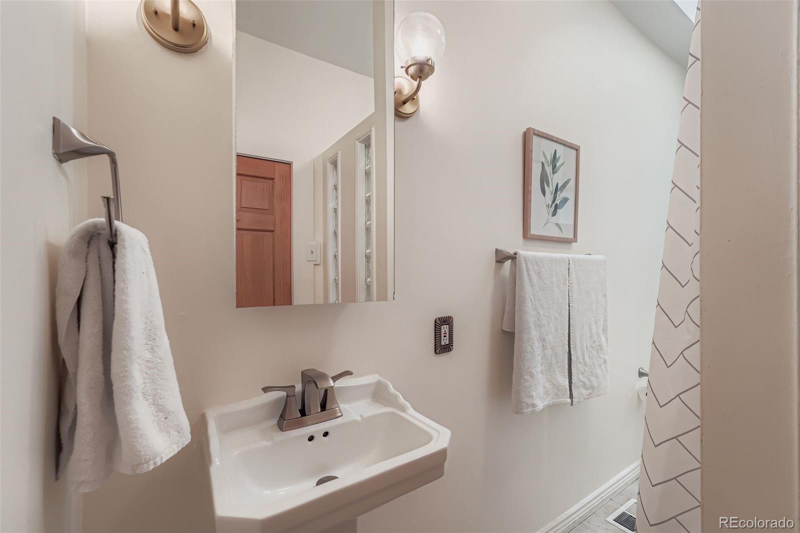 2955 Columbine Street Denver, CO 80205 - Photo 19 of 29 a bathroom with a sink and mirror