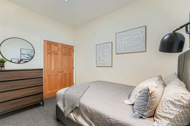 a bedroom with a bed and a painting on the wall