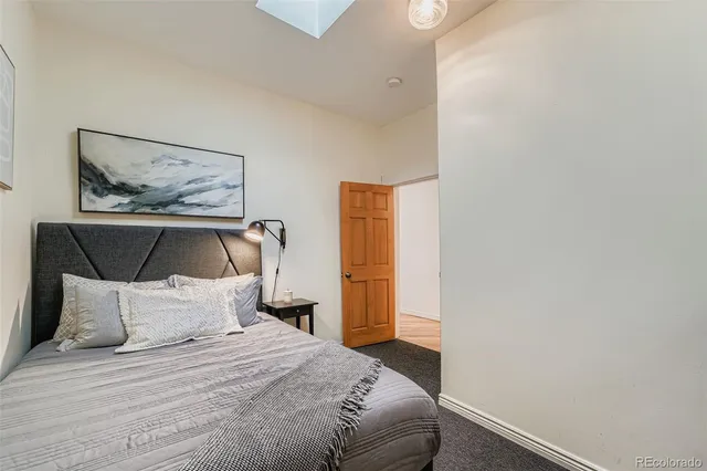 a bedroom with a bed and a painting on the wall