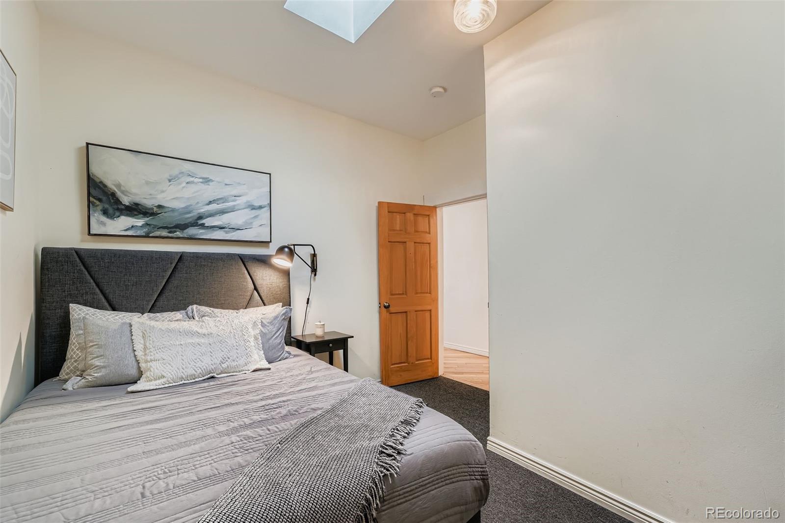 2955 Columbine Street Denver, CO 80205 - Photo 21 of 29 a bedroom with a bed and a painting on the wall