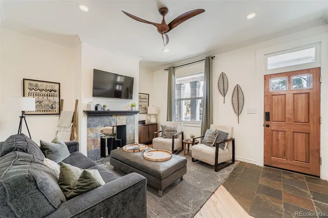 a living room with furniture a flat screen tv and a fireplace