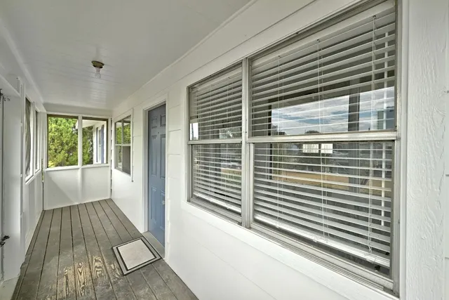 a view of a big room with wooden floor and a chandelier fan in a room