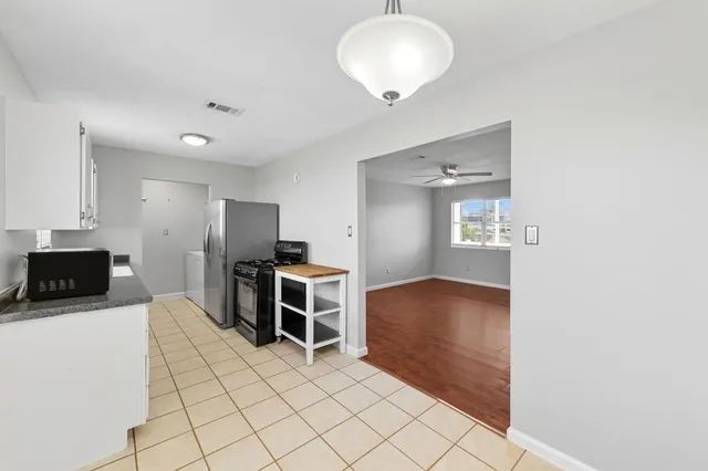 a kitchen with granite countertop a sink stove and cabinets