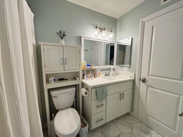a spacious bathroom with a toilet sink and mirror