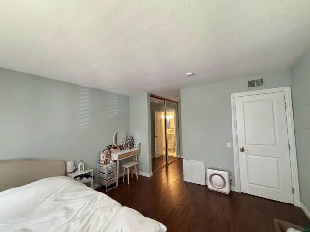 a bedroom with a bed and wooden floor