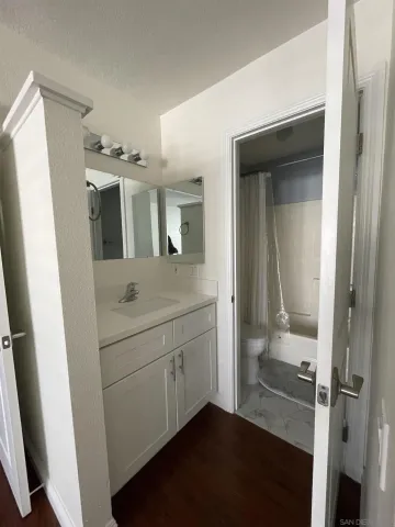 a bathroom with a sink and mirror with toilet