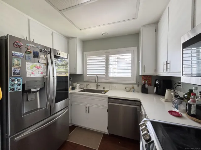 a kitchen that has a lot of cabinets a sink and appliances in it