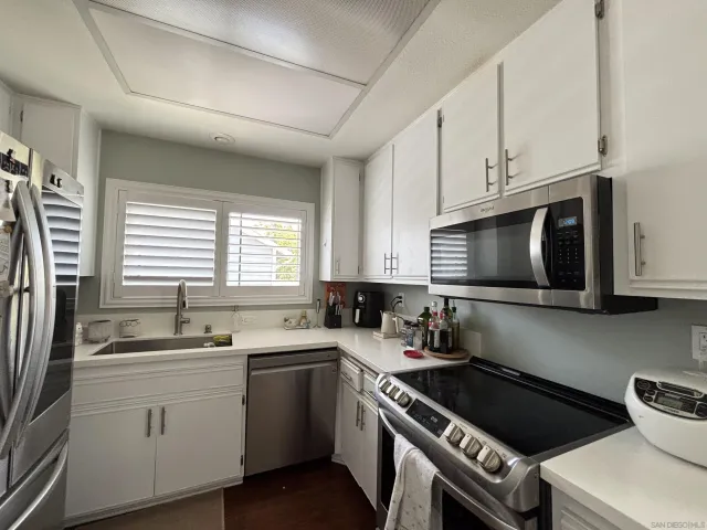 a kitchen with cabinets appliances a sink and a window