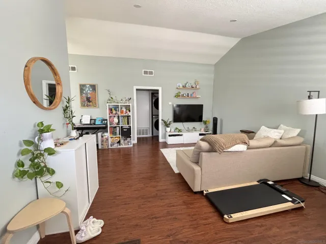 a living room with furniture a chandelier and a flat screen tv