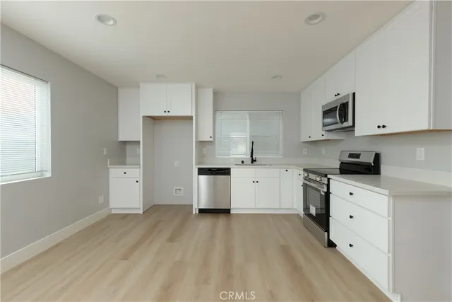 a kitchen with granite countertop white cabinets and white appliances