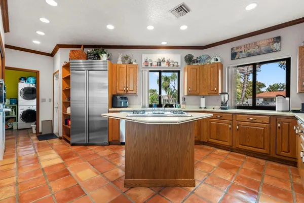 a kitchen with stainless steel appliances granite countertop a sink and a refrigerator