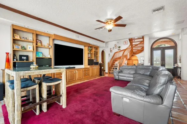 a living room with furniture a flat screen tv and a floor to ceiling window