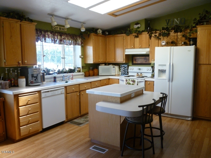 1411 Independence Road Outlook, WA 98938 - Photo 4 of 18 a kitchen with a refrigerator a stove a sink and a dining table with wooden floor