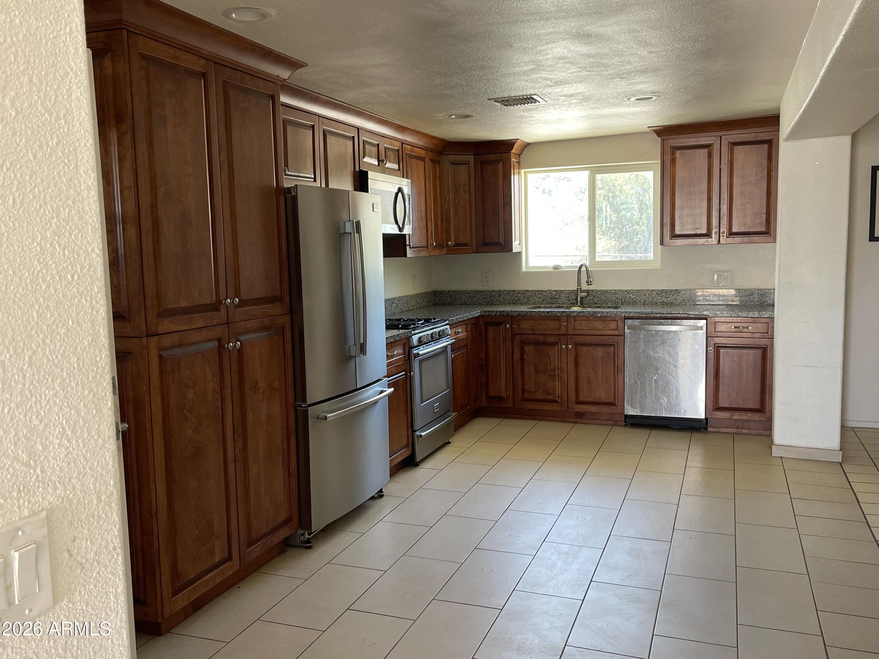 520 West McNeil Street Phoenix, AZ 85041 - Photo 2 of 18 a kitchen with stainless steel appliances granite countertop a refrigerator and a sink