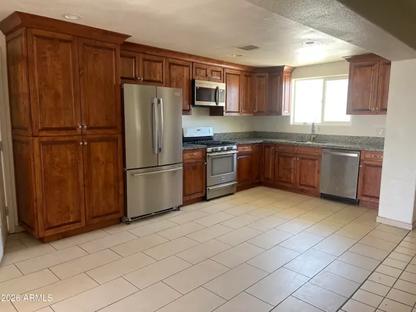 a kitchen with stainless steel appliances granite countertop a refrigerator microwave and sink