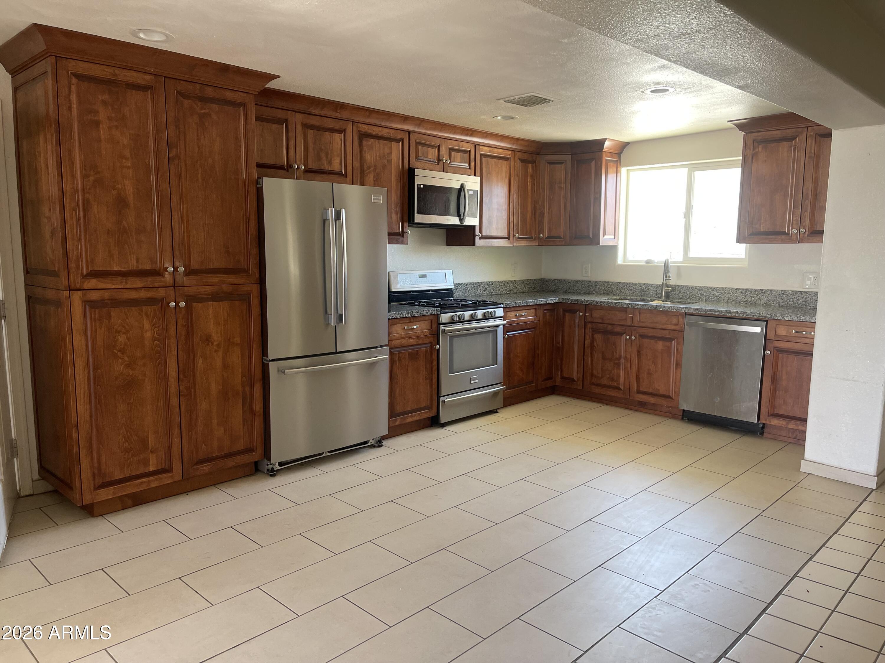 520 West McNeil Street Phoenix, AZ 85041 - Photo 3 of 18 a kitchen with stainless steel appliances granite countertop a refrigerator microwave and sink
