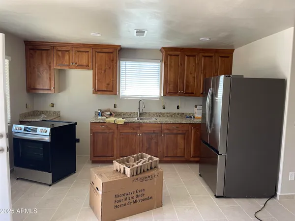 a kitchen with stainless steel appliances granite countertop a refrigerator and a stove top oven