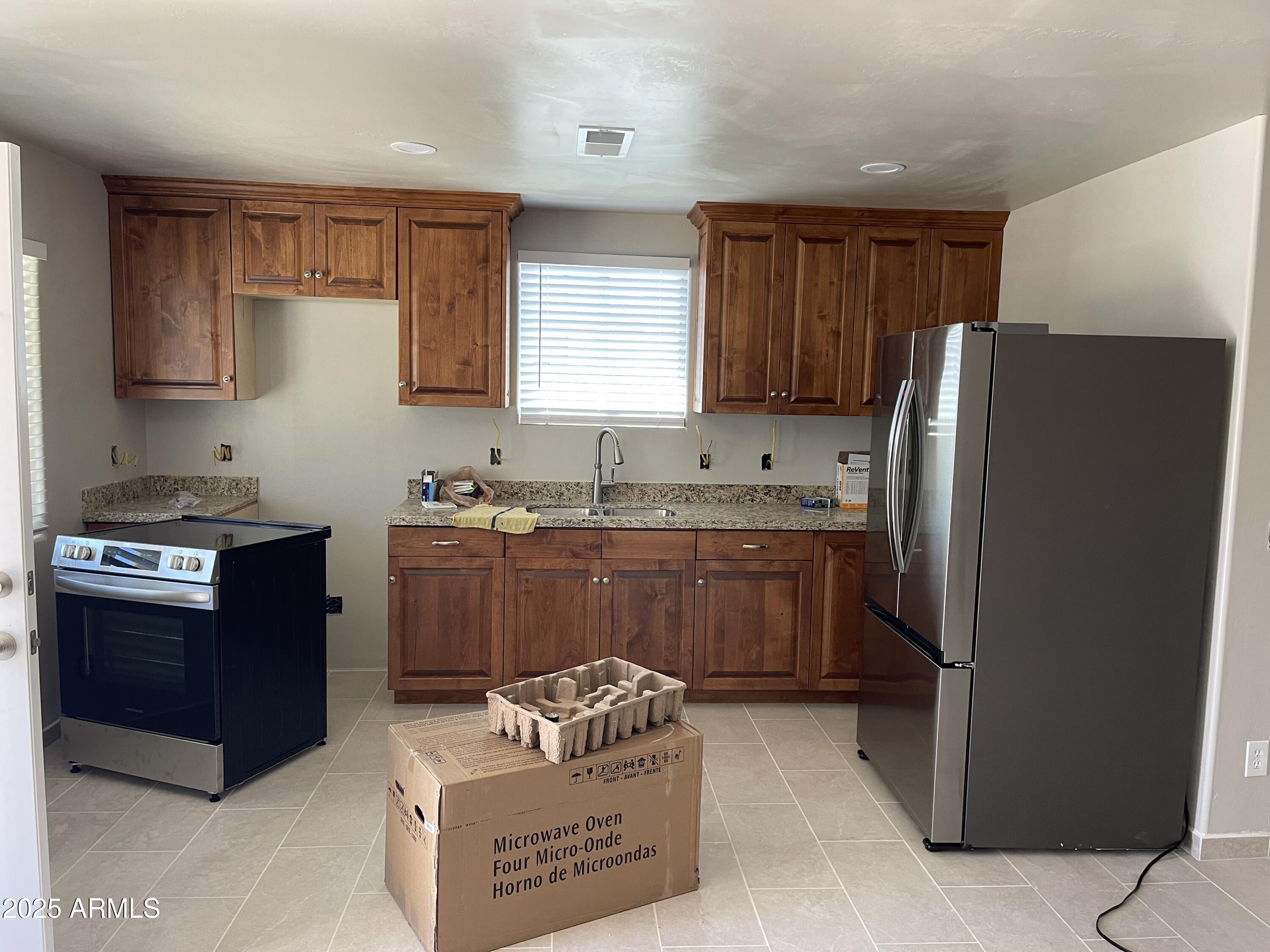 520 West McNeil Street Phoenix, AZ 85041 - Photo 10 of 18 a kitchen with stainless steel appliances granite countertop a refrigerator and a stove top oven