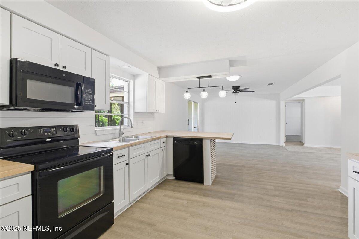 3767 Heath Road Jacksonville, FL 32277 - Photo 13 of 23 a kitchen with granite countertop a stove a sink and dishwasher with wooden floor