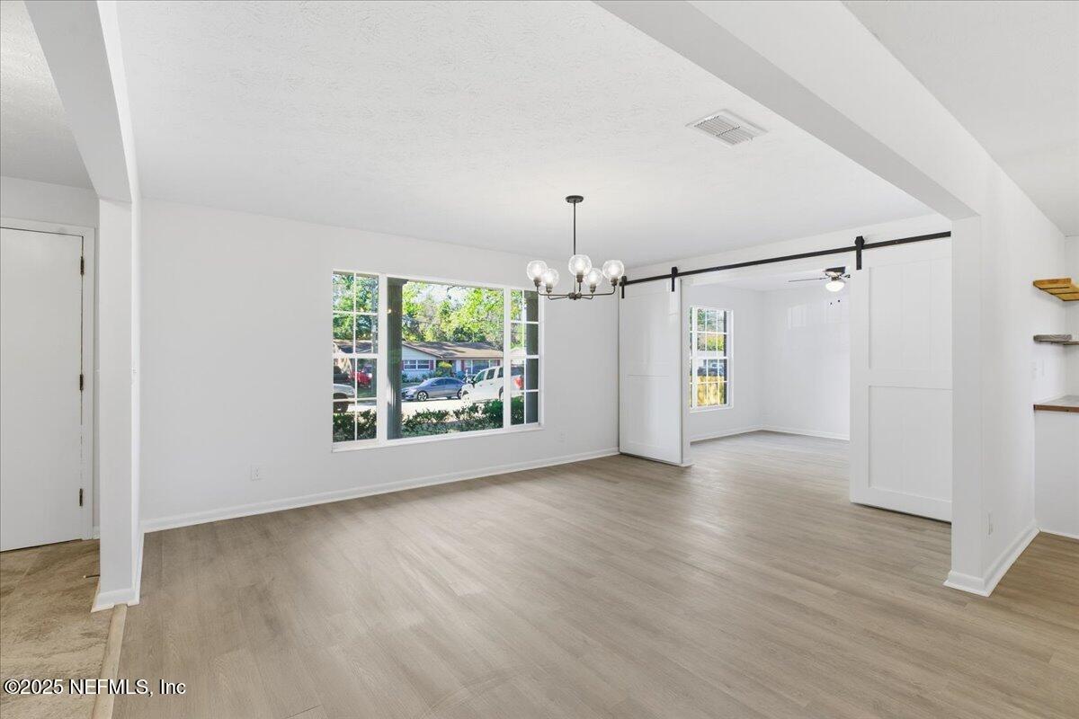 3767 Heath Road Jacksonville, FL 32277 - Photo 8 of 23 an empty room with wooden floor and windows