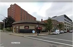 a man walking down a street next to a building