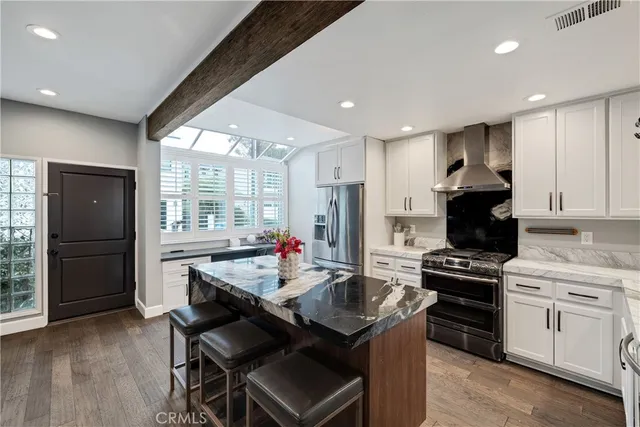 a kitchen with a refrigerator a stove a sink dishwasher with a dining table and chairs