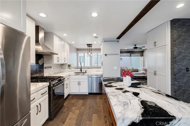 a kitchen that has a lot of cabinets a sink and appliances in it