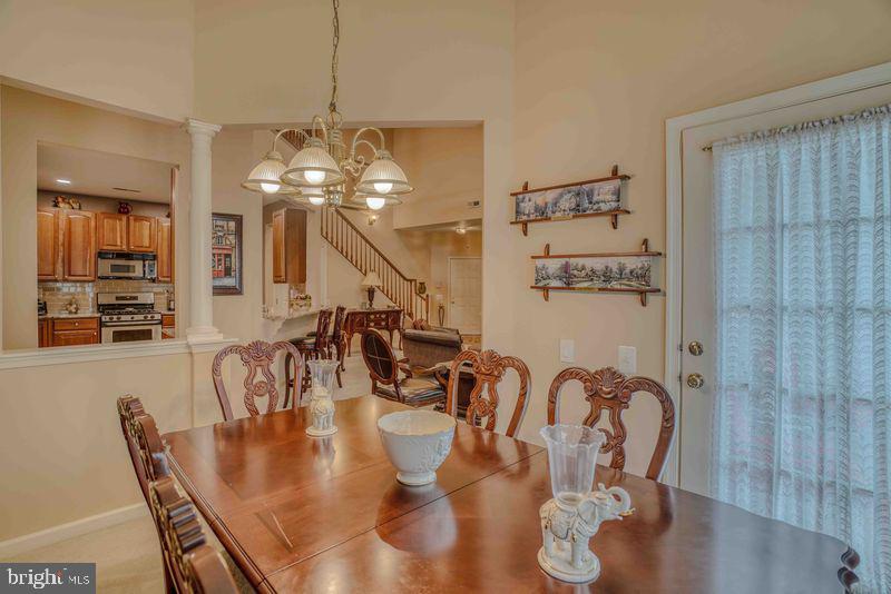 200 Beech Boulevard, Unit 301 Warrington, PA 18976 - Photo 14 of 42 a dining room with wooden floor a chandelier a wooden table and chairs