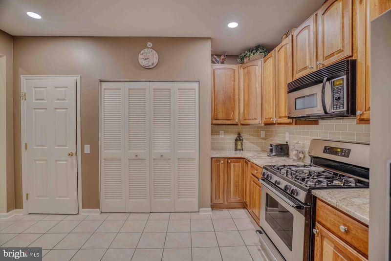 200 Beech Boulevard, Unit 301 Warrington, PA 18976 - Photo 17 of 42 a kitchen with stainless steel appliances granite countertop a stove and a refrigerator