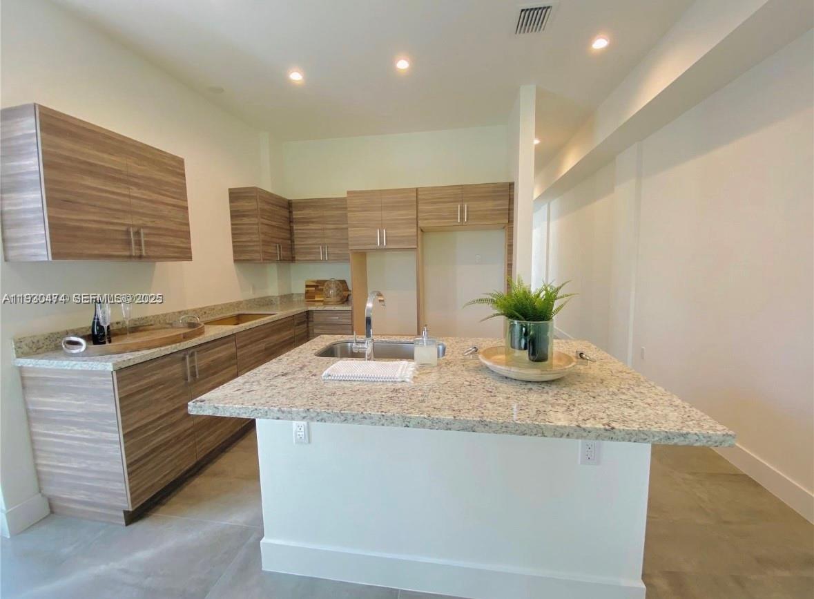 3653 Southwest 25th Street, Unit 3653 Miami, FL 33133 - Photo 15 of 20 a bathroom with a granite countertop sink a toilet and a granite counter tops