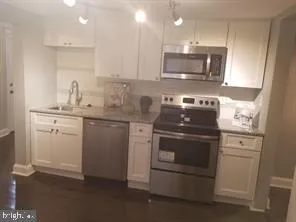 a kitchen with stainless steel appliances granite countertop a sink stove and microwave