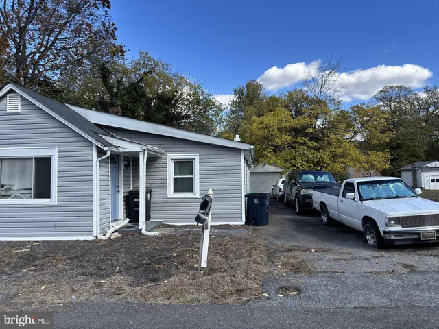 a view of a house with a yard and parking space