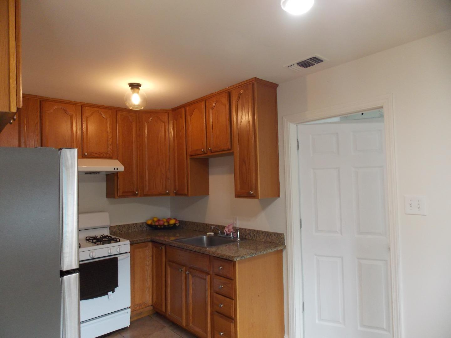 1038 Maple Avenue Vallejo, CA 94591 - Photo 10 of 13 a kitchen with stainless steel appliances granite countertop a stove and a refrigerator