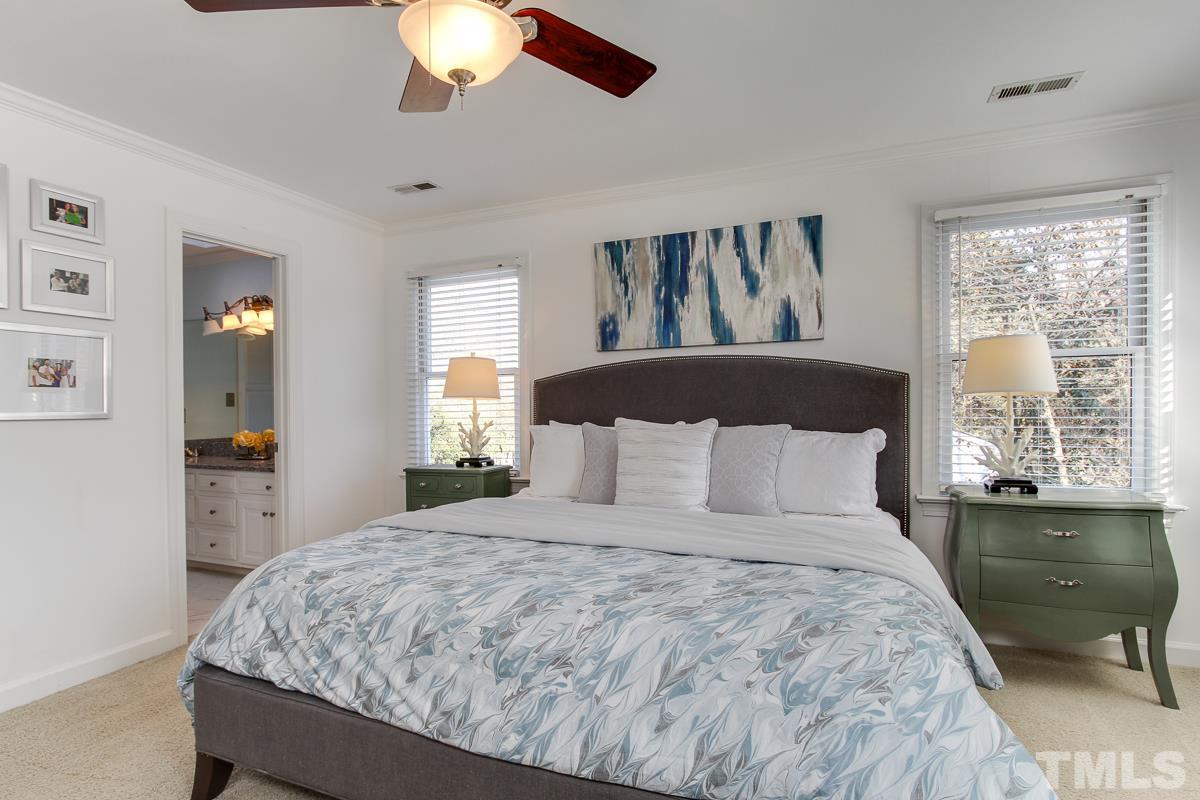312 Dixie Trail Raleigh, NC 27607 - Photo 13 of 25 a large bed sitting in a bedroom next to a window and a chandelier