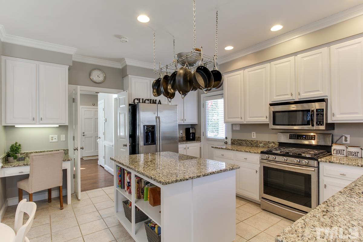 312 Dixie Trail Raleigh, NC 27607 - Photo 7 of 25 a kitchen with stainless steel appliances granite countertop a stove top oven a sink dishwasher a dining table and chairs with wooden floor