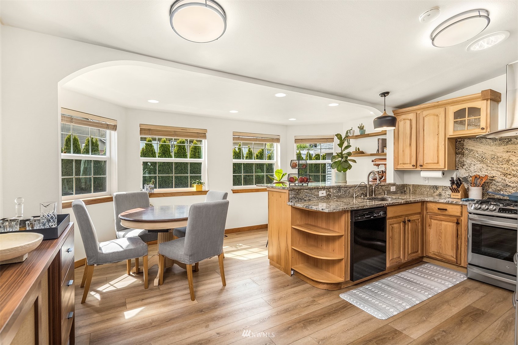 1920 233rd Place Southeast Bothell, WA 98021 - Photo 4 of 29 a dining hall with granite countertop a stove a sink a dining table and chairs with wooden floor