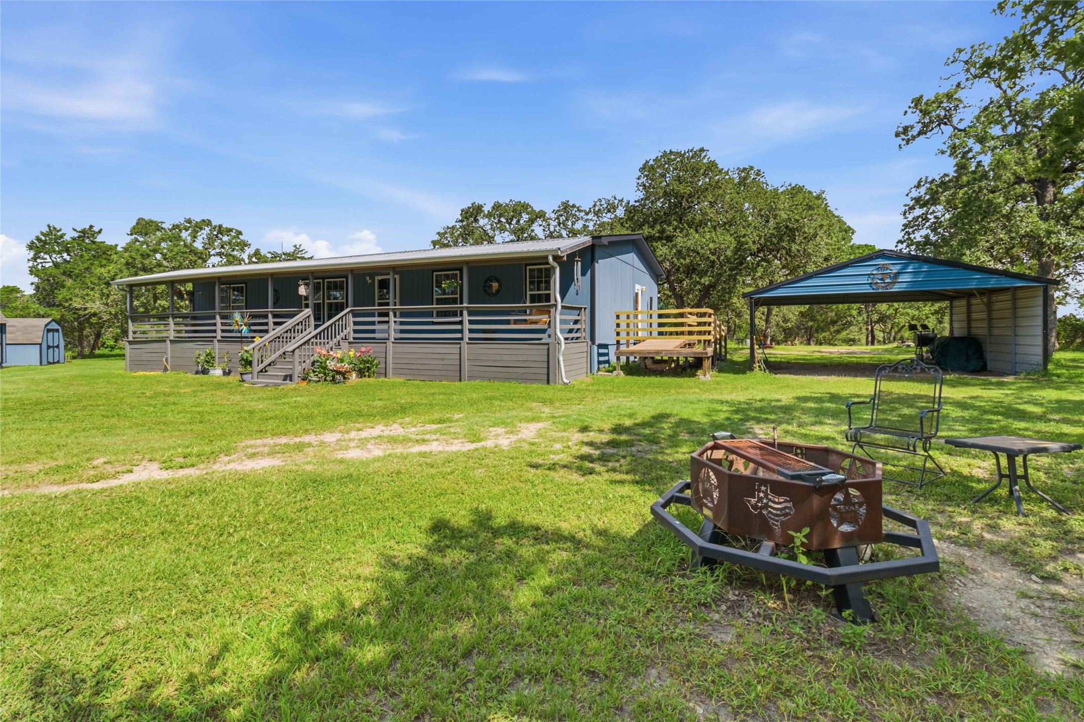 7921 Vista Ranch Road Smithville, TX 78957 - Photo 1 of 39 A charming property featuring a covered porch, outdoor fire pit, and ample green space for enjoyment.