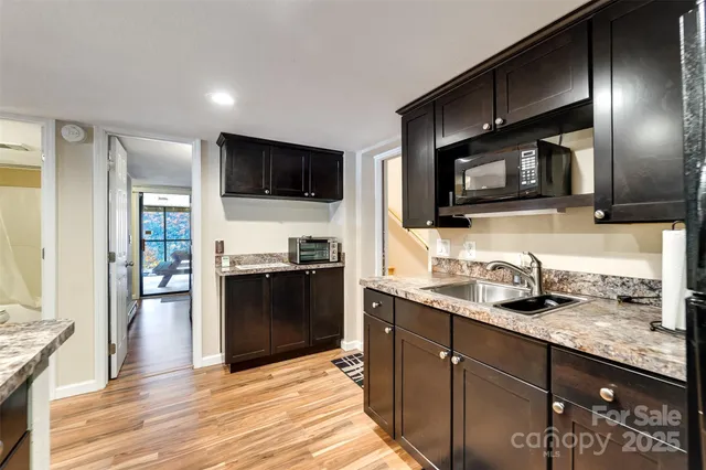 a kitchen with stainless steel appliances granite countertop a stove a sink and a microwave