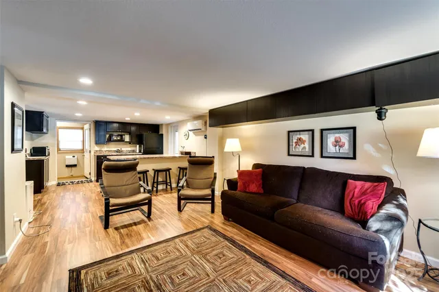 a living room with furniture and view of kitchen