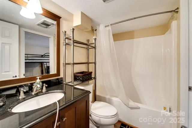 a bathroom with a sink a toilet a mirror and shower