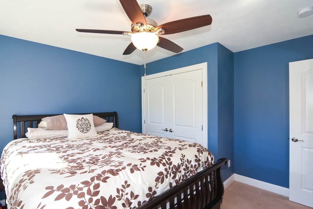 310 Main Street Rutland, MA 01543 - Photo 30 of 39 a bedroom with a large bed and a chandelier