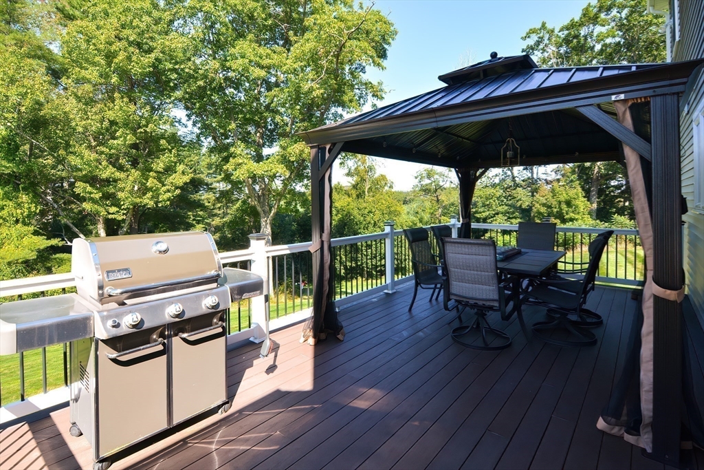 310 Main Street Rutland, MA 01543 - Photo 36 of 39 a view of roof deck with table and chairs under an umbrella with wooden floor