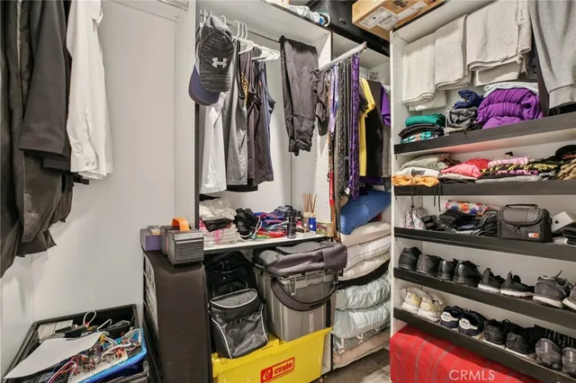 a view of walk in closet with clothes and shoes