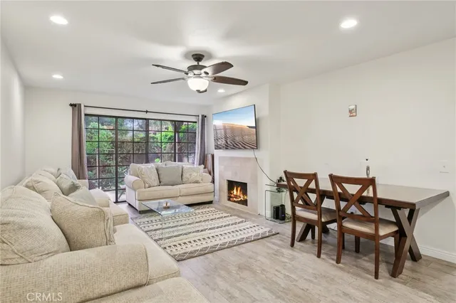 a living room with furniture a fireplace and a floor to ceiling window