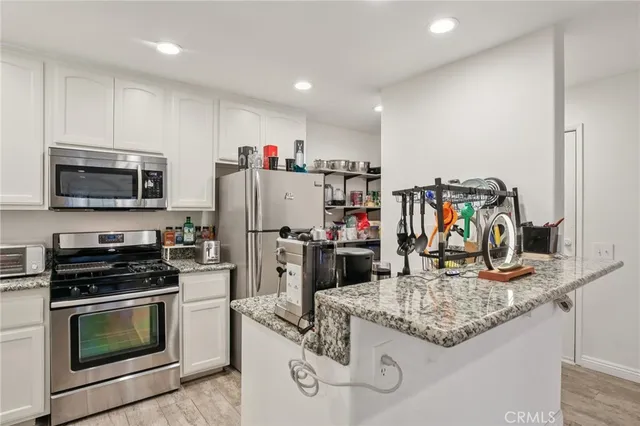 a kitchen with kitchen island granite countertop stainless steel appliances and a sink