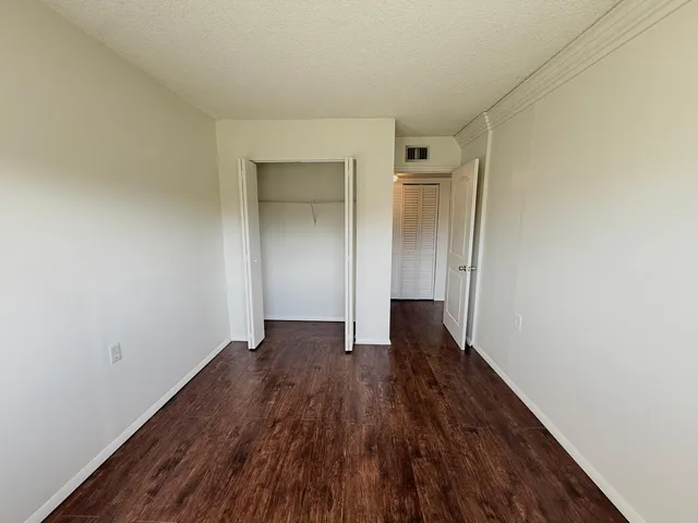 an empty room with wooden floor and closet