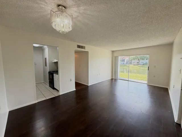 a view of empty room with wooden floor and window